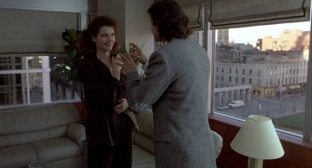 Movie still from “The Fly” (1986), directed by David Cronenberg – A man and a woman are taking a picture of each other; Medium shot, Over the shoulder angle