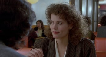 Movie still from “The Fly” (1986), directed by David Cronenberg – A person sitting at a table in a restaurant; Close Up shot, Over the shoulder angle