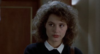 Movie still from “The Fly” (1986), directed by David Cronenberg – A person with curly hair wearing a sweater; Close Up shot, Over the shoulder angle