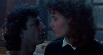 Movie still from “The Fly” (1986), directed by David Cronenberg – A man and a woman face to face in a dark room; Close Up shot, Low angle