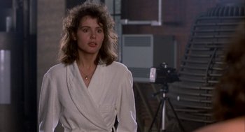 Movie still from “The Fly” (1986), directed by David Cronenberg – A woman standing in front of a video camera; Close Up shot, Over the shoulder angle