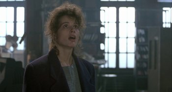 Movie still from “The Fly” (1986), directed by David Cronenberg – A woman in a jacket is looking up at the sky; Close Up shot, Low angle