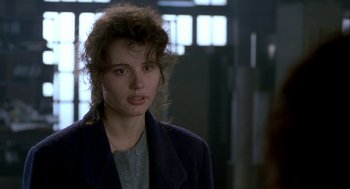 Movie still from “The Fly” (1986), directed by David Cronenberg – A young woman in a black jacket is looking at the camera; Close Up shot, Over the shoulder angle