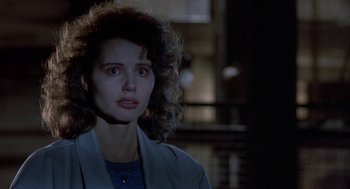 Movie still from “The Fly” (1986), directed by David Cronenberg – A person with curly hair wearing a jacket; Close Up shot, Over the shoulder angle