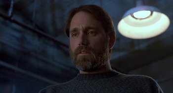 Movie still from “The Fly” (1986), directed by David Cronenberg – A person with a beard wearing a sweater; Close Up shot, Low angle