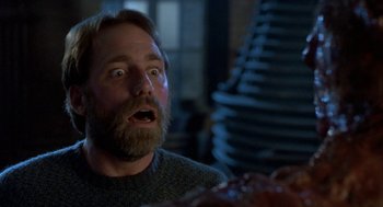 Movie still from “The Fly” (1986), directed by David Cronenberg – A man with a surprised look on his face; Close Up shot, Low angle