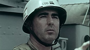 Movie still from “The Fog of War” (2003), directed by Errol Morris – A man wearing a white helmet is looking into the distance; Close Up shot, Low angle