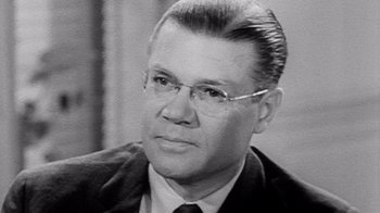 Movie still from “The Fog of War” (2003), directed by Errol Morris – An old photo of a man in a suit and tie; Close Up shot, Low angle