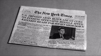 Movie still from “The Fog of War” (2003), directed by Errol Morris – A news paper with a picture of a man in a suit; Extreme Close Up shot, High angle