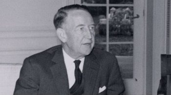 Movie still from “The Fog of War” (2003), directed by Errol Morris – An old black and white photo of a man in a suit; Close Up shot, Over the shoulder angle