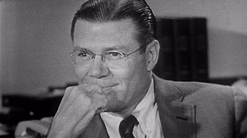 Movie still from “The Fog of War” (2003), directed by Errol Morris – An older man in a suit and tie; Close Up shot, Over the shoulder angle