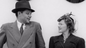 Movie still from “The Fog of War” (2003), directed by Errol Morris – An old photo of a man and a woman standing next to each other; Medium shot, Low angle