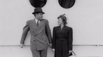 Movie still from “The Fog of War” (2003), directed by Errol Morris – A man and a woman standing next to each other; Medium shot, Low angle