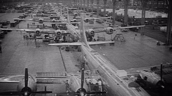 Movie still from “The Fog of War” (2003), directed by Errol Morris – An aerial view of airplanes in a hangar; Extreme Wide shot, High angle