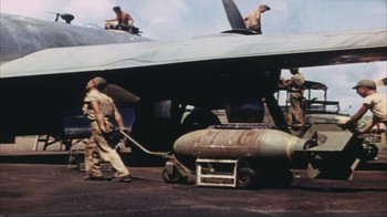 Movie still from “The Fog of War” (2003), directed by Errol Morris – A group of men working on an airplane; Wide shot, High angle
