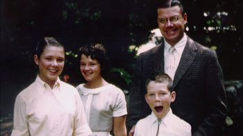 Movie still from “The Fog of War” (2003), directed by Errol Morris – A group of people standing next to each other in front of trees; Close Up shot, High angle
