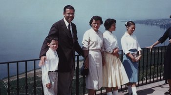 Movie still from “The Fog of War” (2003), directed by Errol Morris – An old photo of a man and a woman and two young boys; Wide shot, High angle