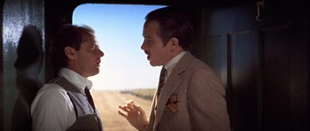 Movie still from “The Fortune” (1975), directed by Mike Nichols – A man and a woman talking in front of an open window; Medium shot, Over the shoulder angle