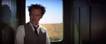 Movie still from “The Fortune” (1975), directed by Mike Nichols – A man standing in front of an open window on a train; Medium shot, Over the shoulder angle