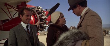 Movie still from “The Fortune” (1975), directed by Mike Nichols – A man and a woman standing next to each other; Close Up shot, Over the shoulder angle