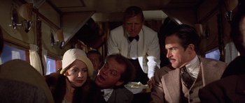 Movie still from “The Fortune” (1975), directed by Mike Nichols – A group of people sitting on top of an airplane; Medium shot, Over the shoulder angle