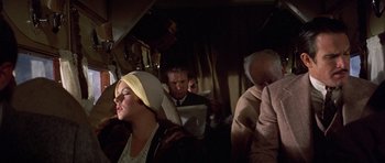 Movie still from “The Fortune” (1975), directed by Mike Nichols – A group of people sitting on a train; Medium shot, Over the shoulder angle