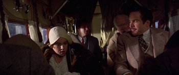 Movie still from “The Fortune” (1975), directed by Mike Nichols – A group of people sitting on a train; Close Up shot, Over the shoulder angle