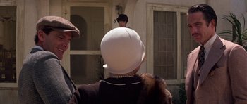 Movie still from “The Fortune” (1975), directed by Mike Nichols – A woman wearing a white hat and a black hat; Close Up shot, Over the shoulder angle