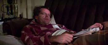 Movie still from “The Fortune” (1975), directed by Mike Nichols – A man laying in a bed with a blanket over his head; Medium shot, High angle