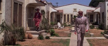 Movie still from “The Fortune” (1975), directed by Mike Nichols – A man in a robe walking down the steps of a house; Wide shot, Low angle