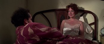 Movie still from “The Fortune” (1975), directed by Mike Nichols – A man and a woman sitting on a bed; Medium shot, Over the shoulder angle