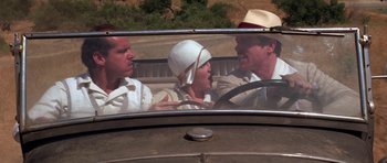 Movie still from “The Fortune” (1975), directed by Mike Nichols – A group of people riding in the back of an old car; Close Up shot, Over the shoulder angle