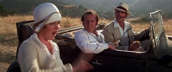 Movie still from “The Fortune” (1975), directed by Mike Nichols – A group of people riding in the back of a car; Medium shot, Over the shoulder angle