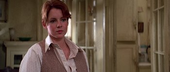 Movie still from “The Fortune” (1975), directed by Mike Nichols – A woman with red hair wearing a brown vest; Close Up shot, Low angle