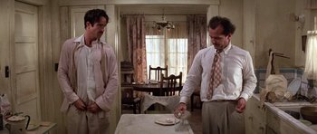 Movie still from “The Fortune” (1975), directed by Mike Nichols – A couple of men standing next to each other; Medium shot, Low angle