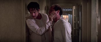 Movie still from “The Fortune” (1975), directed by Mike Nichols – Two men in white shirts and ties one of them is covering his face; Close Up shot, Over the shoulder angle