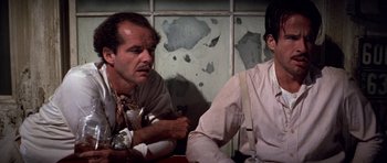 Movie still from “The Fortune” (1975), directed by Mike Nichols – Two men sitting at a table in front of a broken window; Close Up shot, Low angle