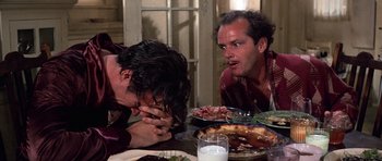 Movie still from “The Fortune” (1975), directed by Mike Nichols – A couple of people sitting at a table with food; Close Up shot, Over the shoulder angle