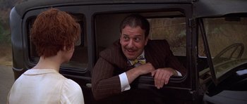 Movie still from “The Fortune” (1975), directed by Mike Nichols – A man sitting in the back seat of a car; Close Up shot, Over the shoulder angle