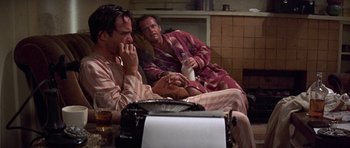 Movie still from “The Fortune” (1975), directed by Mike Nichols – A couple of men sitting next to each other on a couch; Medium shot, Low angle