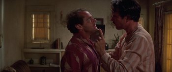 Movie still from “The Fortune” (1975), directed by Mike Nichols – Two men in a living room one of them is putting lipstick on the other; Close Up shot, Over the shoulder angle