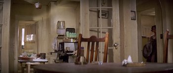 Movie still from “The Fortune” (1975), directed by Mike Nichols – A view of a room with a table and chairs; Wide shot, High angle
