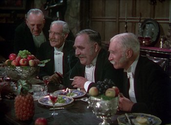 Movie still from “The Four Feathers” (1939), directed by Zoltan Korda – A group of men sitting at a dinner table; Medium shot, High angle