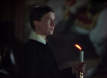 Movie still from “The Four Feathers” (1939), directed by Zoltan Korda – A young man holding a lit candle in a dark room; Close Up shot, Low angle