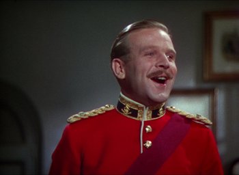 Movie still from “The Four Feathers” (1939), directed by Zoltan Korda – A man in a red and gold military uniform with a mustache; Close Up shot, Low angle