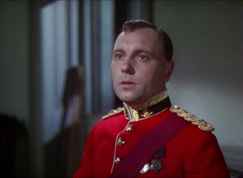 Movie still from “The Four Feathers” (1939), directed by Zoltan Korda – A man in a red and gold military uniform; Close Up shot, Low angle