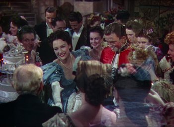 Movie still from “The Four Feathers” (1939), directed by Zoltan Korda – A group of people sitting around a table; Medium shot, High angle