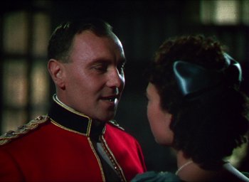Movie still from “The Four Feathers” (1939), directed by Zoltan Korda – A man in a red and black uniform talking to a woman; Close Up shot, Over the shoulder angle
