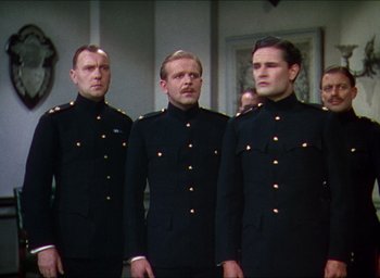 Movie still from “The Four Feathers” (1939), directed by Zoltan Korda – A group of men standing next to each other wearing uniforms; Medium shot, Low angle