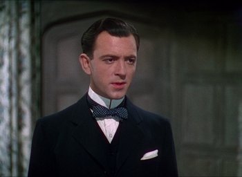 Movie still from “The Four Feathers” (1939), directed by Zoltan Korda – A man wearing a suit and bow tie; Close Up shot, Low angle